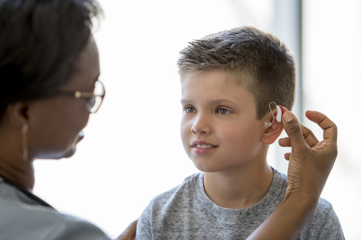 Young boy being fitted with a new hearing aid